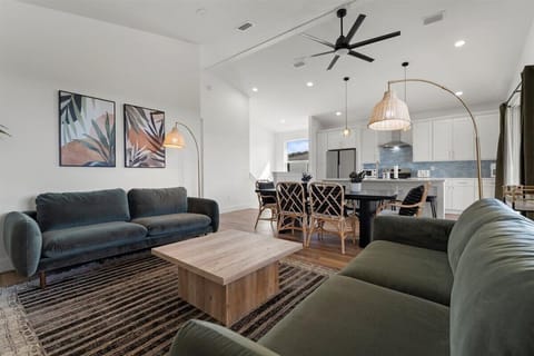 Spacious open-concept living area with contemporary décor, plush seating, and seamless flow into the kitchen and dining room.