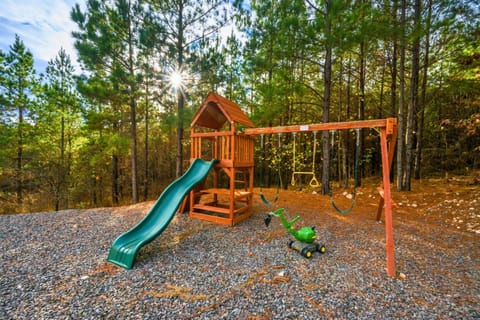 Playful Paradise: Adventure awaits with a vibrant swing set and slide amidst the serene pines!