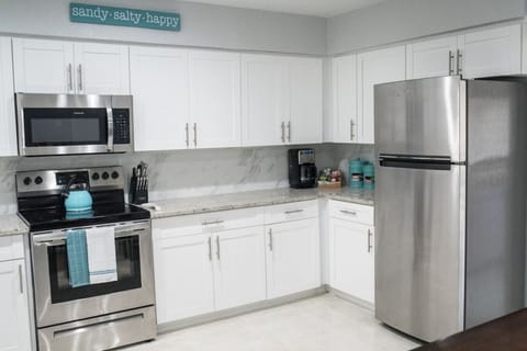 Kitchen delights await!  Unleash your culinary skills in our kitchen, featuring a dishwasher, refrigerator with ice and water dispenser, stove, and microwave. Fuel your day with Dunkin` Donuts coffee, assorted creamers, sugars, and teas.
