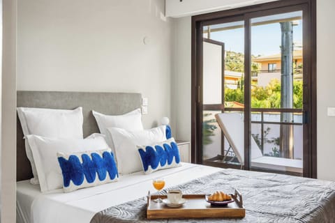 Bright, breezy bedroom with balcony access — wake up wrapped in light, texture, and tranquil views.