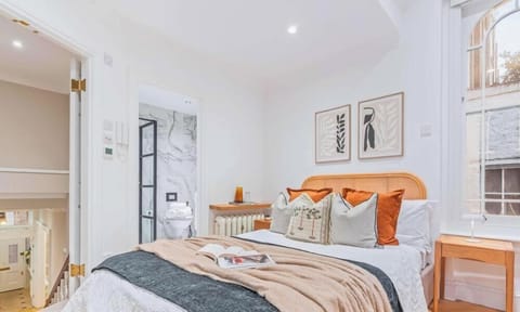 Double bed with herringbone floors & arched windows framing leafy views