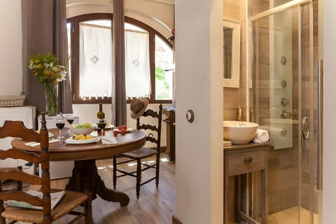 Enjoy an intimate meal at the rustic wooden dining table, bathed in natural light from the charming arched window.
