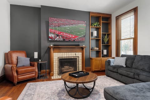 Cozy living room with decorative fireplace, 75" smart TV,  comfortable seating and pull out queen sleeper sectional sofa.