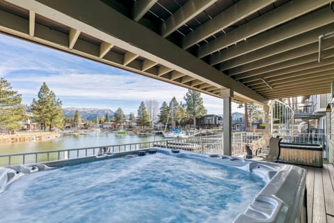 Relax in the spacious covered hot tub with waterfront views