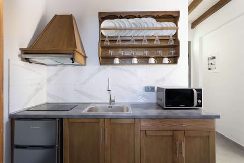 Modern Kitchenette with Window Lighting and Open Wooden Shelving
Bright, functional kitchen equipped with essentials and accented with open shelving for easy access to cookware.