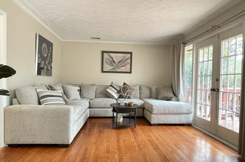 Comfy sectional couch in living room with original hardwood floors throughout.