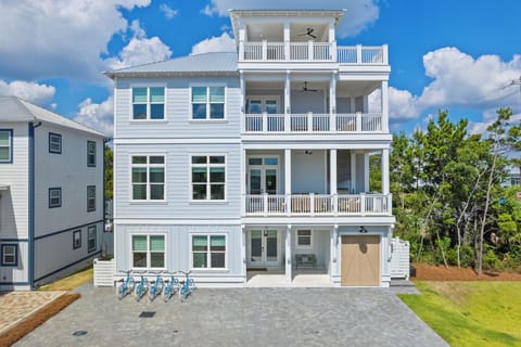 This stunning four-story coastal retreat features three expansive covered balconies and a top-level sun deck, offering endless outdoor living.