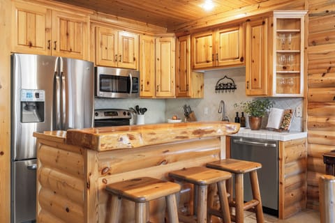 Kitchen with barstool seating and modern appliances.