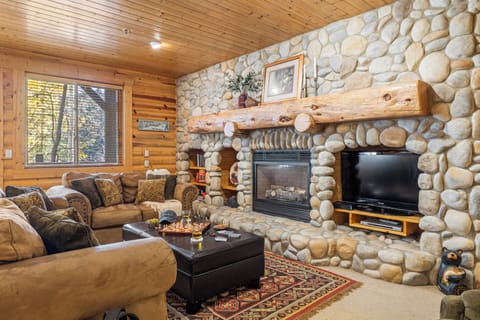 Cozy living room with TV, comfortable sofa, and fireplace.