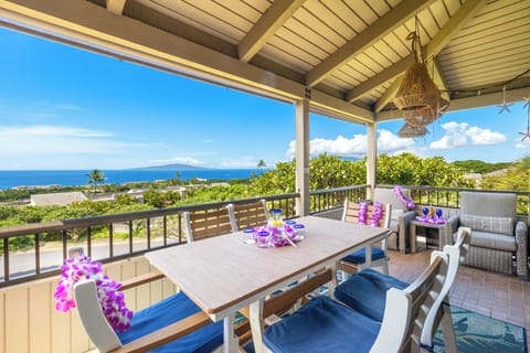 Patios open with orchids and ocean views, tables set beneath cushioned chairs.