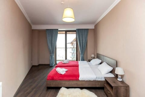 Enjoy a well-lit bedroom with two single beds combined for added comfort, complemented by fresh linens and a relaxing ambiance.