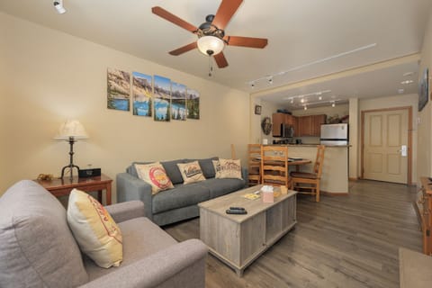 Relax in your spacious living area with comfortable seating, mountain artwork, and an open kitchen perfect for preparing meals together.