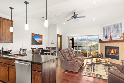 Unwind in your open-concept retreat where a crackling fireplace meets mountain views through expansive windows.