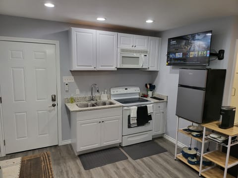 Full kitchen w/ double sink, stove/oven, microwave, freezer/fridge, & utensils