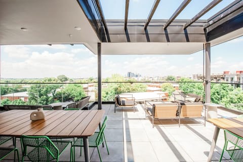 Enjoy coffee or evening chats on a stylish rooftop with comfy seating, shade, and stunning Charlotte skyline views.