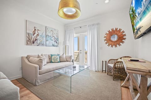Bright coastal living space with balcony access