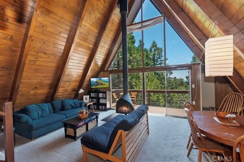 Iconic 1960s A-Frame living room with dramatic vaulted ceilings, glowing Mid-Cen