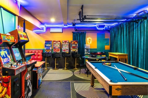 Indoor game area with pool, poker, karaoke, and arcade machines.