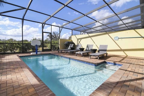Enjoy a private screened pool area with lounge chairs and a basketball hoop for family-friendly fun.