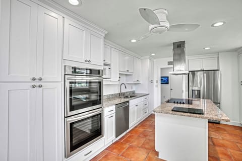 Prepare meals effortlessly in the bright kitchen, featuring a spacious island, double ovens, and a sleek sink.