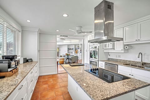 The chef's kitchen stands ready—granite, stainless appliances, and an oversized island.
