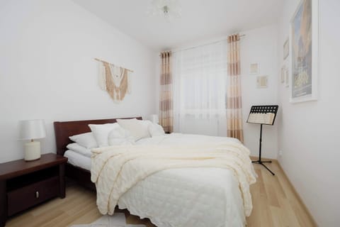 Bright bedroom with a comfortable double bed and large windows.