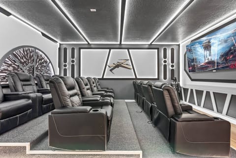 Experience our unique home theater with plush, reclining black leather seats for the best viewing. The illuminated ceiling and stunning wall art set the perfect atmosphere for unforgettable movie nights or gaming sessions.