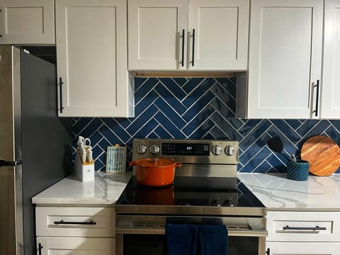 Glass-top stove and oven with counterspace and cooking/baking tools.