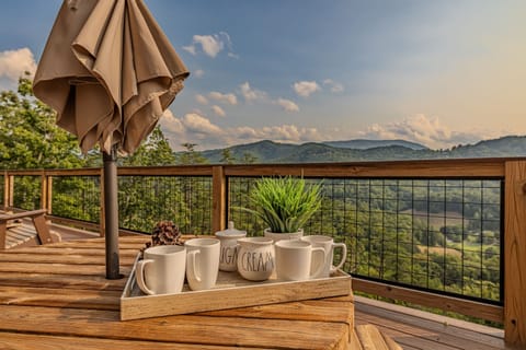 Start your day with a cup of coffee and this view. This expansive deck offers a breathtaking, panoramic view of the mountains, providing the perfect backdrop for morning conversations or evening relaxation.