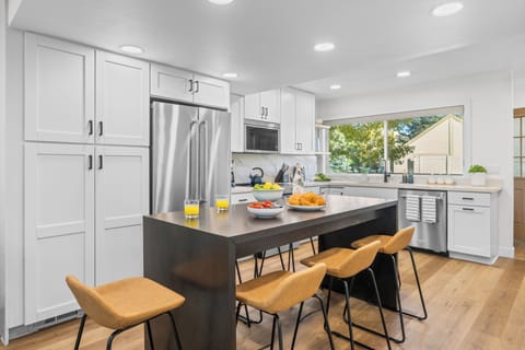 Updated kitchen with stainless steel appliances and island seating.