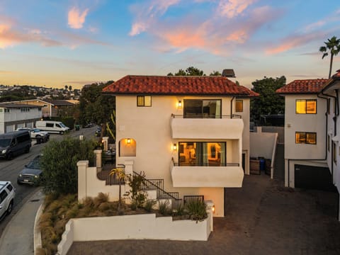 Exterior of home with balcony and sunset view.