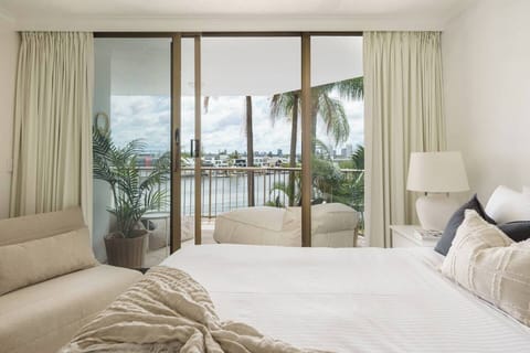 The queen-sized primary bedroom offers uninterrupted views of the Nerang River and opens directly onto the private balcony.