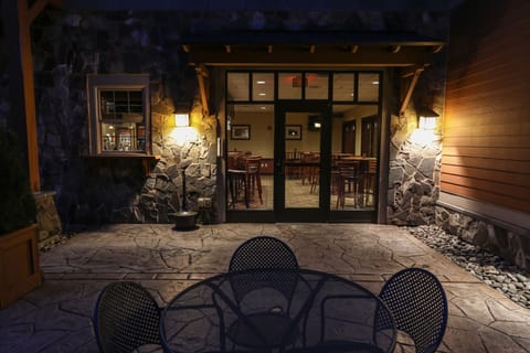 Charming entrance glowing under warm evening lights, welcoming you to a cozy mountain retreat.