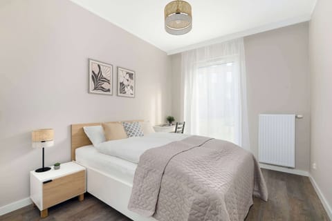 A serene bedroom with a double bed, bedside lamps, and soft bedding. The room is decorated in gentle neutrals for a peaceful atmosphere.