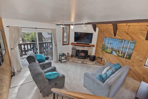Cozy cabin living: fireplace, big TV, comfy seating. Deck access!