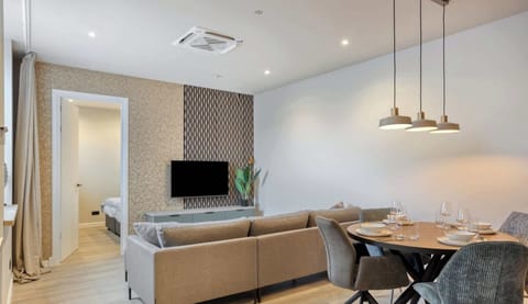 Open-plan layout with a comfortable sofa, elegant dining area, and soft lighting.