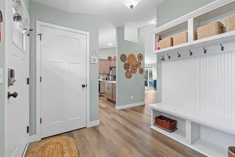 Step into this welcoming entryway where built-in bench and storage cubbies keep your gear organized while soft green walls create a calming arrival.
