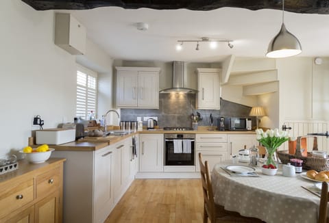 Open-plan well-equipped kitchen with dining table seating four guests