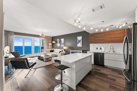 Living Room + Kitchen Ocean View – Spacious open-concept living area with floor-to-ceiling windows framing the Gulf.