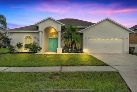 Experience a warm welcome at this beautiful home, featuring elegant outdoor lighting and a vibrant green grass. This house offer a peaciful atmosphere and a spacious front lawn for your perfect Florida stay.