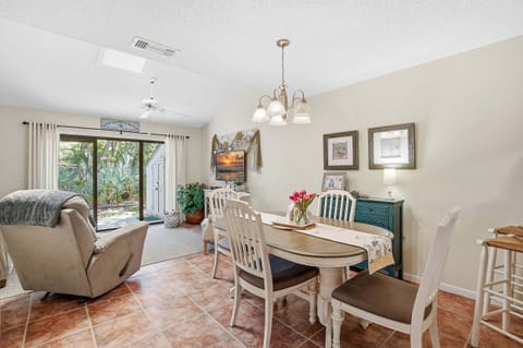 Bright open-concept beach stay featuring a cozy dining area and living space with sliding doors to a private patio. Enjoy indoor-outdoor coastal living, natural light, and a relaxing atmosphere near the beach.
