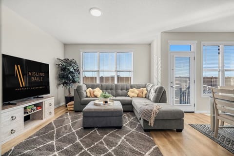 Main floor living room with a Smart TV, board games, cozy sectional and walkout access to the backyard.