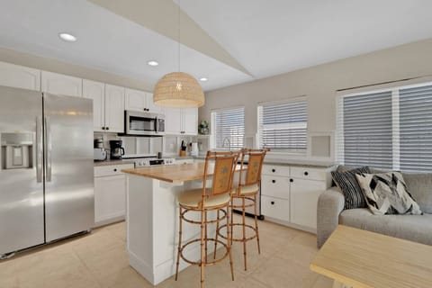 An eating bar with a pair bar stools separates the kitchen from the living area.