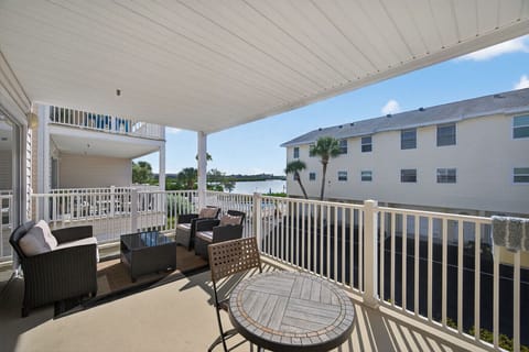 Covered balcony w/ seating, overlooking the complex for easy indoor-outdoor lounging.