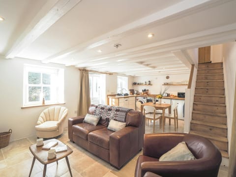 Coffee table, sofas, view into kitchen and up the stairs