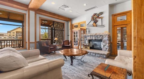 Inviting lobby with a grand stone fireplace and mountain views, creating a warm space to relax after outdoor adventures.