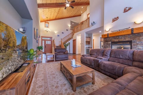 Spacious great room (living room, dining area, kitchen) with vaulted ceilings, see through gas fireplace, 65 inch SmartTV and comfortable furnishings.
