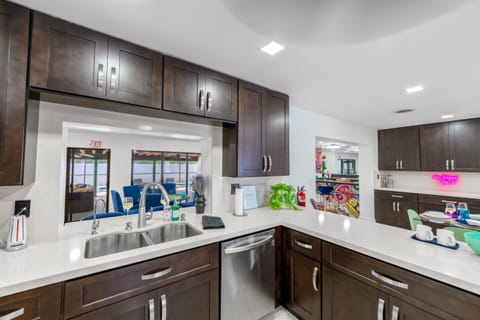 COOK TOGETHER FAMILY FUN! Fully-equipped kitchen with modern appliances with a  pass-through window, overlooking the  pool . Perfect for families who love homemade meals. #Familyfriendlyairbnb #Largehomeairbnb 