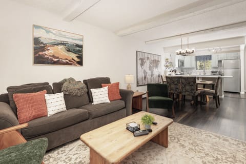 Sink into plush sofas in your beautifully appointed living space, where modern comfort meets rustic charm with exposed beams overhead.