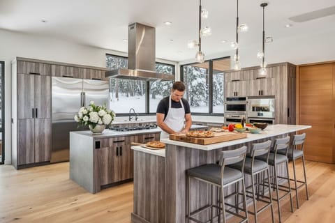 Chef's Dream – Monogram appliances, induction cooktop, pizza oven, and integrated PITT gas burners provide restaurant level performance in a sleek, modern setting.